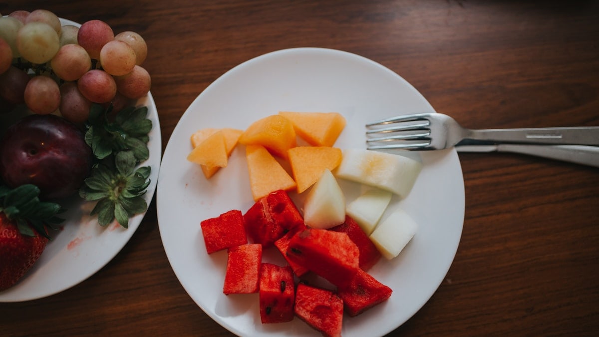 sliced watermelon and mango on plate with fork